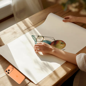 Framed print of Steve Jobs-inspired glasses in front of a red apple. Purchase for a chance to win an Apple iPhone 17 Pro.