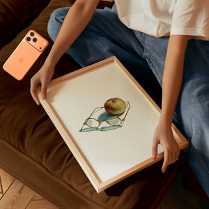 Framed print of Steve Jobs-inspired glasses in front of a red apple. Purchase for a chance to win an Apple iPhone 17 Pro.